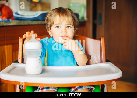 Gemischte Rassen Babyjungen Trinkflasche im Hochstuhl Stockfoto