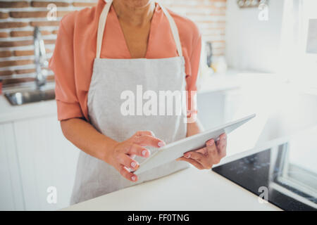 Ältere Frau kaukasischen mit digital-Tablette in Küche Stockfoto