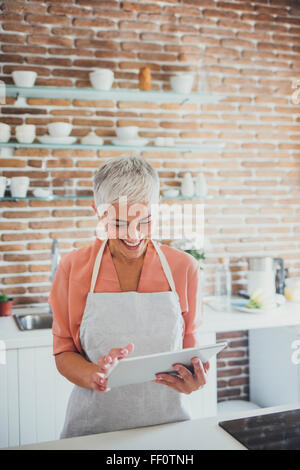 Ältere Frau kaukasischen mit digital-Tablette in Küche Stockfoto