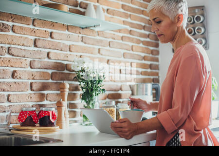 Ältere Frau kaukasischen mit digital-Tablette in Küche Stockfoto