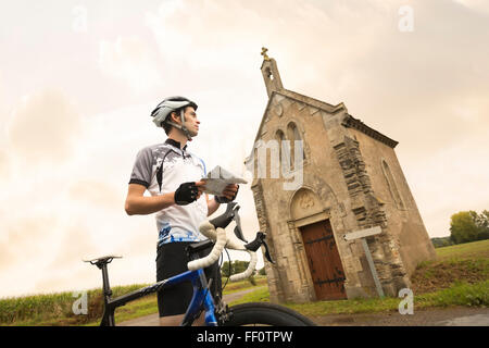 Kaukasische Radfahrer lesen Karte in der Nähe von Kirche Stockfoto