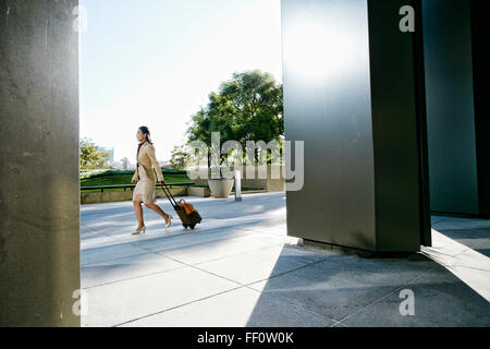 Asiatische Geschäftsfrau rollenden Gepäck im freien Stockfoto