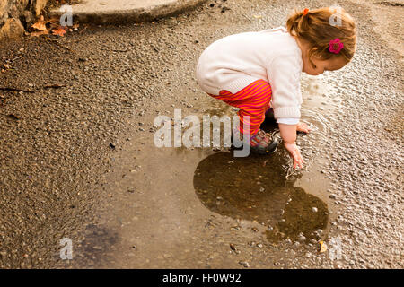 Kaukasische Mädchen spielen in Pfütze Stockfoto