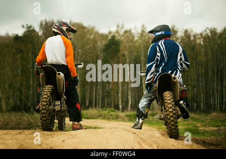 Kaukasische Männer reiten Dirtbikes unterwegs Stockfoto