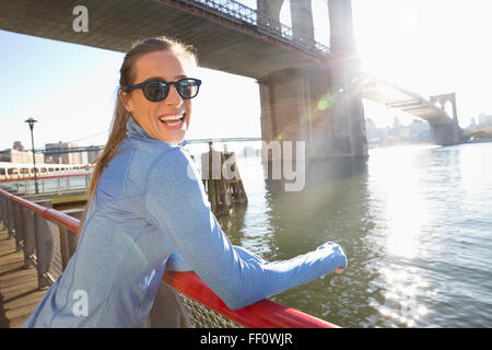 Kaukasische Frau lächelnd an Uferpromenade, New York, New York, Vereinigte Staaten von Amerika Stockfoto