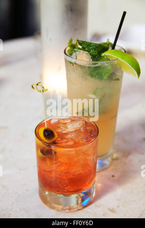 Zwei Cocktails, ein Manhattan auf den Felsen und einen Mojito, sitzt auf einem Marmor Zähler nach oben. Stockfoto