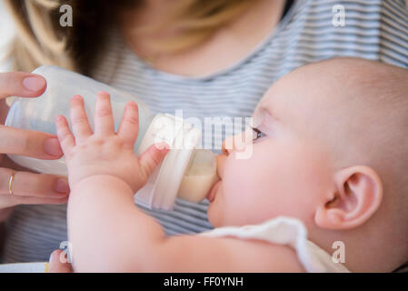 Kaukasische Mutter Fütterung Baby Tochter Stockfoto