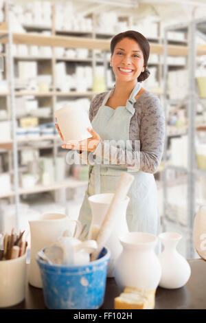 Gemischte Rassen Potter lächelnd in Werkstatt Stockfoto