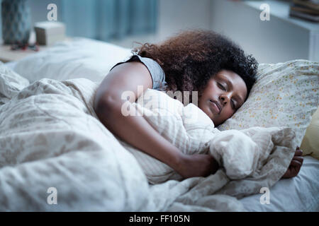 Schwarze Frau im Bett schlafen Stockfoto