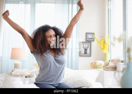 Schwarze Frau auf Bett dehnen Stockfoto