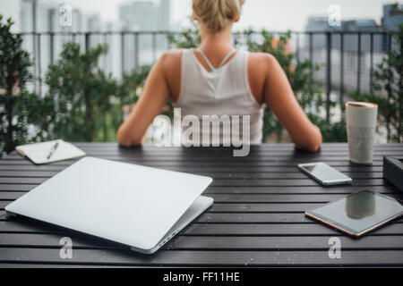 Kaukasische Frau sitzt auf Balkon Stockfoto