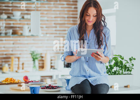 Kaukasische Frau mit digital-Tablette in Küche Stockfoto