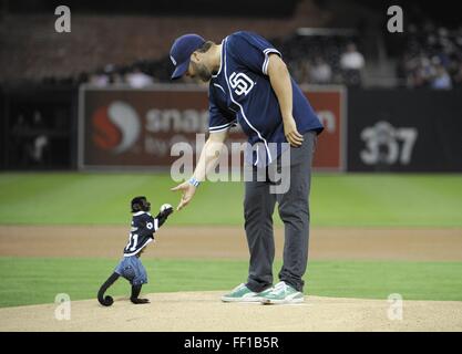 Peking, China. 10. Februar 2016. Eine Affe Hände einen Baseball mit dem Schauspieler Tyler Labine während ein Baseball-Spiel in San Diego, USA, 27. September 2012. 2016 markiert das Jahr des Affen im chinesischen Kalender. Clevere Affen bringen oft unerwartete Unterhaltung Geist in die Sportarena. © Xinhua/Alamy Live-Nachrichten Stockfoto