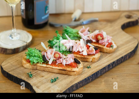 Schinkenscheiben gerollt und auf einem Salatblatt angeordnet. Stockfoto