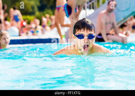 Mann mit Brille Swimmning im Pool. Sommerliche Hitze, Wasser. Stockfoto