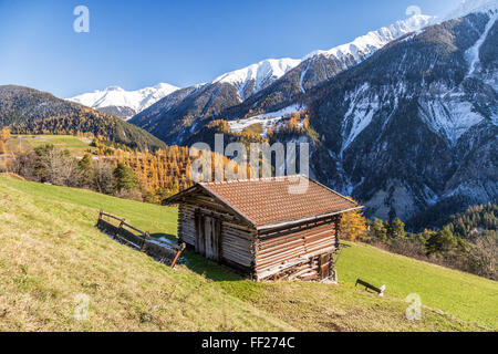 Holzhütte, umgeben von bunten Wäldern und schneebedeckten Gipfeln, Schmitten, Albula Bezirk, Kanton Graubünden, Schweiz, Europa Stockfoto