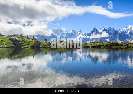 Niedrige Wolken und Nebel um Grandes Jorasses und Mont-Blanc, während Wanderer am Lac De Cheserys, Haute Savoie, französischen Alpen gehen Stockfoto