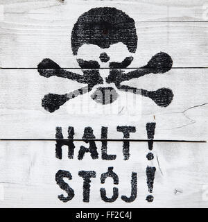 Halt! Stoj! Stop-Schild, in Deutsch und Polnisch, mit einem bemalten Schädel. Stockfoto