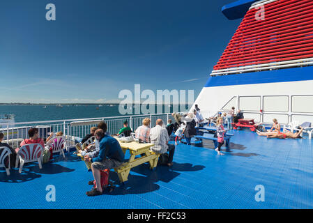 Passagiere, die zum Sonnenbaden an Deck der Fähre von Rostock nach Schweden an der deutschen Küste in Warnemünde suchen Stockfoto