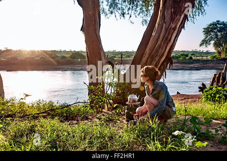 Eine junge Frau beobachtet die EarRMy Morgen RMight WhiRMe camping in Ostafrika, Samburu NationaRM Park, Kenia, Afrika Stockfoto