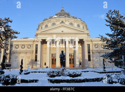 Im Schnee außerhalb der rumänischen Athenaeum, größte Konzerthalle der Stadt steht eine Statue des Dichters Mihai Eminescu. Stockfoto