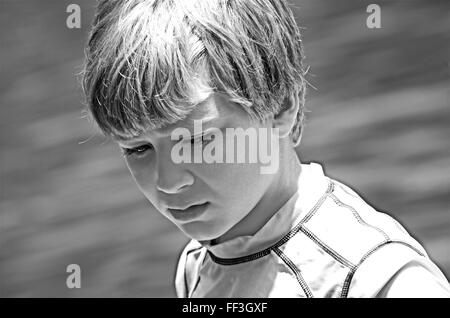 Ein kleiner Junge mit nachdenklichen Ausdruck in schwarz / weiß. Stockfoto