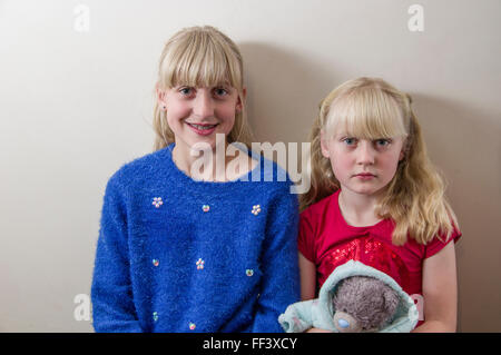 Studio-Porträt von zwei junge, blonde Mädchen vor einem weißen Hintergrund. Stockfoto