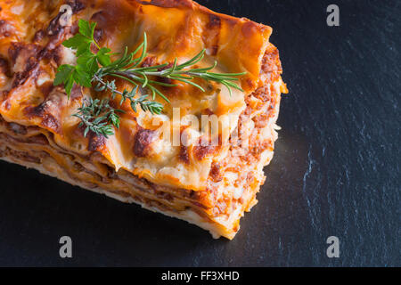 heiß dampfende Lasagne mit Rotwein auf Schiefer und Holz Tisch Stockfoto