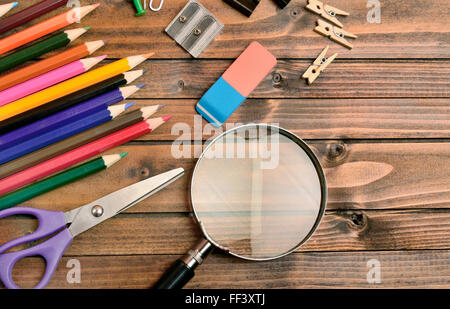 Lupe mit Bürobedarf auf Tisch Stockfoto