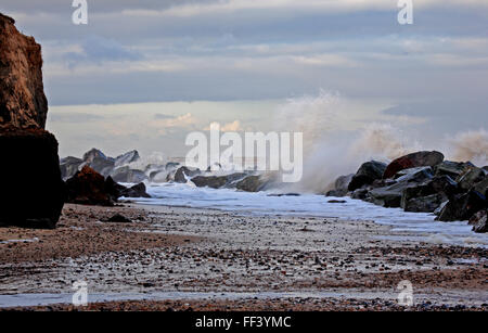 Felsenmeer Rüstung Verteidigung wird von Wellen bei Happisburgh, Norfolk, England, Vereinigtes Königreich zerschlagen. Stockfoto