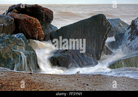 Ein Blick auf das Meer infiltrieren Rock Rüstung Küstenschutzes an der Ostküste bei Happisburgh, Norfolk, England, Vereinigtes Königreich. Stockfoto