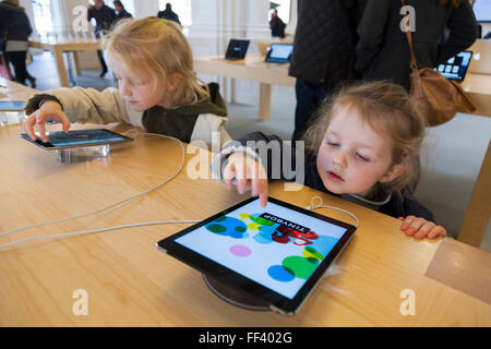 Drei Jahre altes Mädchen / Kind / Kinder, konzentriert sich bei der Verwendung eines iPad ich Pad tablet-Computer. Apple Store Amsterdam Niederlande Stockfoto