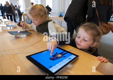 Drei Jahre altes Mädchen / Kind / Kinder, konzentriert sich bei der Verwendung eines iPad ich Pad tablet-Computer. Apple Store Amsterdam Niederlande Stockfoto