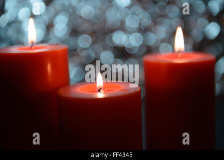 drei große aromatische Kerzen leuchten vor schönen Bokeh Hintergrund, Valentinstag Stockfoto