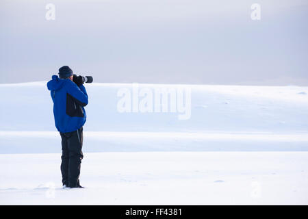 Minimalistische Bild des Fotografen Fotografieren von Schnee bedeckte Landschaft in Island im Januar Stockfoto
