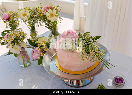 Hochzeitstorte und Blumensträuße auf dem Tisch Stockfoto