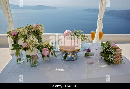 Hochzeitstorte und Blumensträuße auf den Tisch, gegen das Meer. Griechenland. Stockfoto