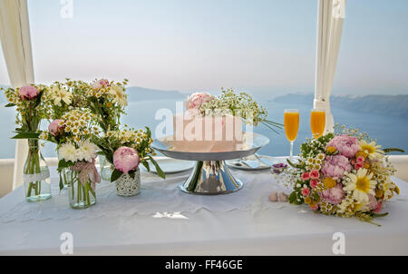 Hochzeitstorte und Blumensträuße auf den Tisch, gegen das Meer. Griechenland. Stockfoto