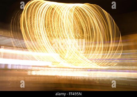 Bewegungsunschärfe eines sich drehenden Riesenrad bei Nacht Stockfoto