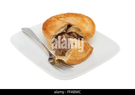 Fleischpastete mit einer Scheibe ausgeschnitten auf einem Teller mit einer Gabel isoliert gegen weiß Stockfoto