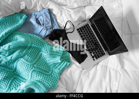 Weiblichen Outfit und ein Laptop auf Bett, Morgenlicht angelegt Stockfoto