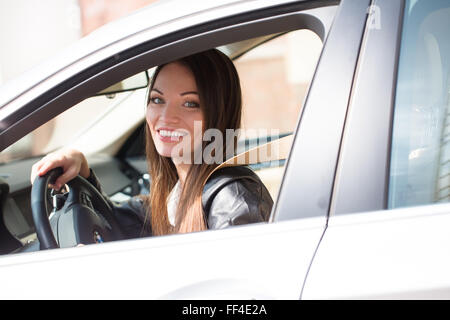 Porträt der schönen jungen Frau in das neue Auto - im freien Stockfoto