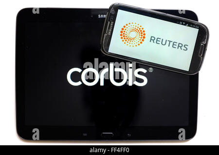 Das Reuters-Logo auf einem Smartphone und Corbis auf einem Tablet vor weißem Hintergrund fotografiert. Stockfoto