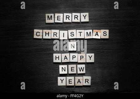 Frohe Weihnachten und ein frohes neues Konzept auf schwarzem Hintergrund Stockfoto