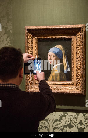 Tourist unter Bild des berühmten Gemälde "Mädchen mit Perlenohrring" von vermeer Stockfoto