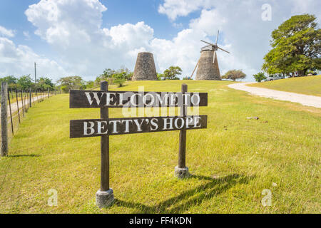 Zeichen und Windmühlen bei Betty es Hope, einer ehemaligen Zuckerrohrplantage, jetzt ein Museum, Antigua, Antigua und Barbuda an einem sonnigen Tag zu nennen. Stockfoto