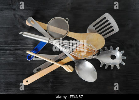 Satz von Küchenutensilien auf schwarzem Hintergrund Stockfoto