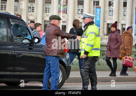 London, UK, 10. Februar 2016, Taxifahrer halten Hände in gespielter Geste Handschellen anziehen. Polizei stoppen Taxi auf Westminster Bridge dafür einen U-Turn nach links abbiegen gesagt.  Etwa 8000 Taxis blockiert die Straße Whitehall, Trafalgar Square und Westminster Bridge als Protest gegen die app Uber und TFL Erteilung von Mini-Taxi-Lizenzen. Bildnachweis: JOHNNY ARMSTEAD/Alamy Live-Nachrichten Stockfoto