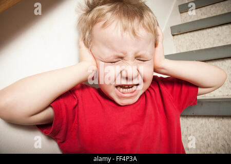 Vernachlässigte einsame Kind an die Wand gelehnt Stockfoto