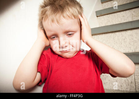 Vernachlässigte einsame Kind an die Wand gelehnt Stockfoto